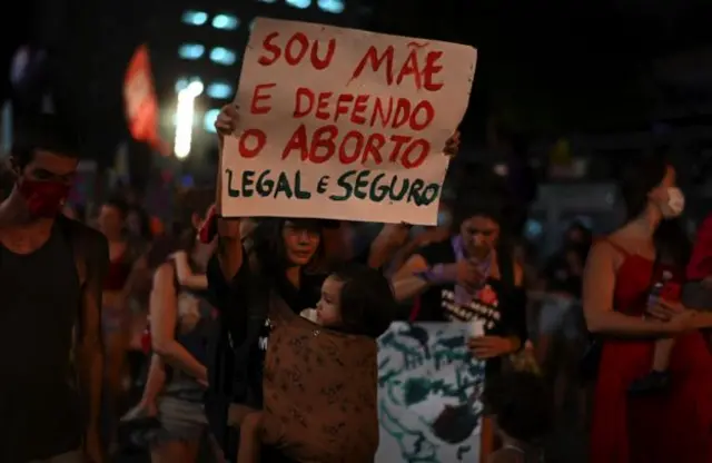 Manifestante com cartaz escrito Sou Mãe e defendo o aborto legal e seguro