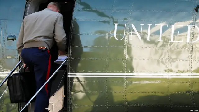 A US marine carries the nuclear football onto a helicopter in November