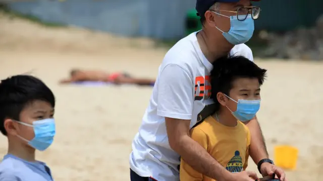 Un papa et ses deux enfants sur la plage