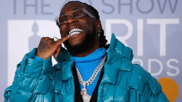 Mawakin Najeriya Burna boy na dariya bayan ya isa wajen bikin raba kyautuka na BRIT da aka yi a Landan a ranar Talata 18 ga watan Fabrairun 2020.