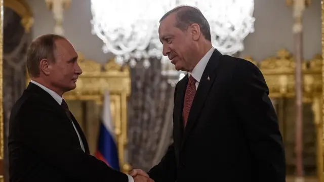 Rusya Devlet Başkanı Vladimir Putin (solda), Cumhurbaşkanı Recep Tayyip Erdoğan ile el sıkışırken.