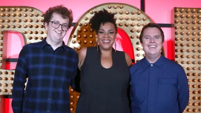 Pelham ao lado dos comediantes Desiree Burch e Paul McCaffrey