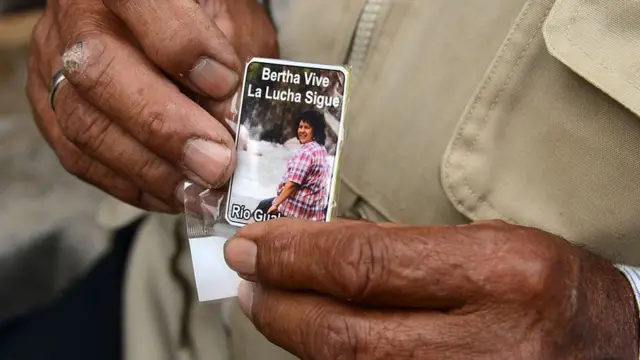 Un ciudadano hondureño muestra una estampa con la imagen de Berta Cáceres