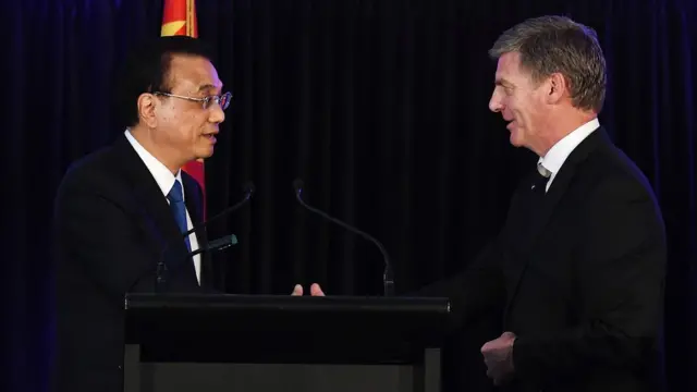 New Zealand's Prime Minister Bill English (R) shakes hands with China's Premier Li Keqiang after a joint press conference in Wellington on March 27, 2017.