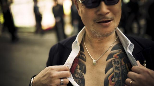 A man showing off tattoos
