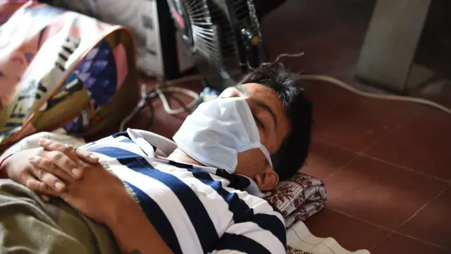 मास्क पहने लेटा बीमार