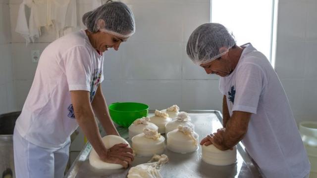 Maria Lúcia e Ivair produzindo queijo