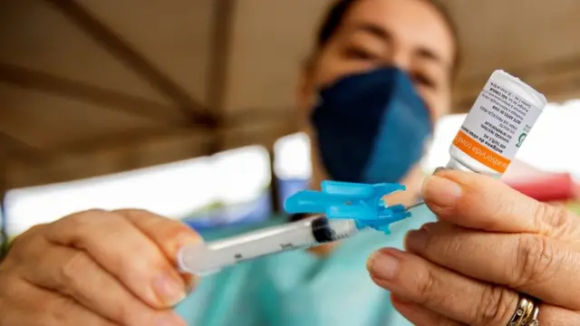 Mulher segurando vacina