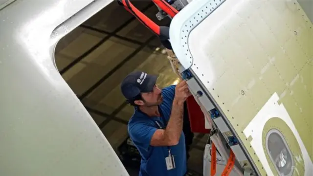 Homem ajustando porta de avião