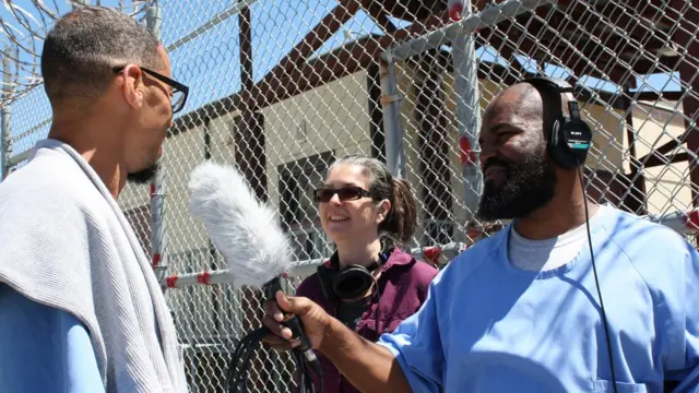 Earlonne Woods entrevista a un preso de la cárcel de San Quintín ante la mirada de Nigel Poor
