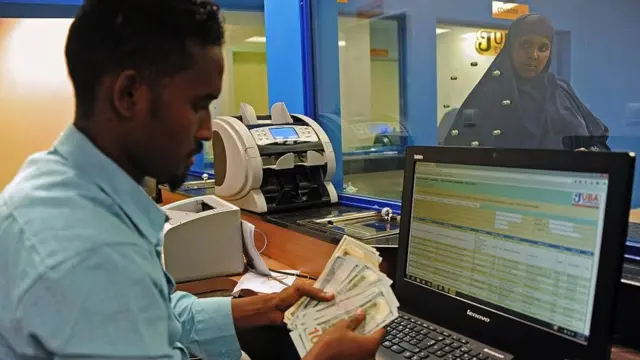 A woman collects money at a money transfer agency in Mogadishu, 2015