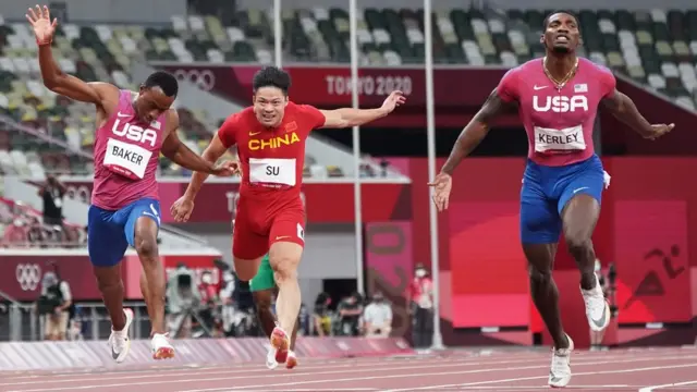 Tokyo 2020 Olympics - Athletics - Men"s 100m - Final - OLS - Olympic Stadium, Tokyo, Japan - August 1, 2021. Su Bingtian of China and Ronnie Baker of United States and Fred Kerley of the United States crossing the line