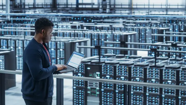 Una persona frente a decenas de supercomputadores.