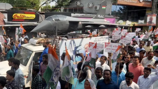 રફાલની પ્રતિકૃતિ સાથે લોકો