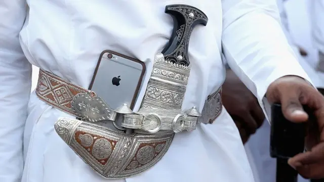 Điện thoại di động iPhone đuợc gài vào đai ngay cạnh con dao găm Omani truyền thống tại buổi lễ ở Muscat, Oman (5/11/2016)