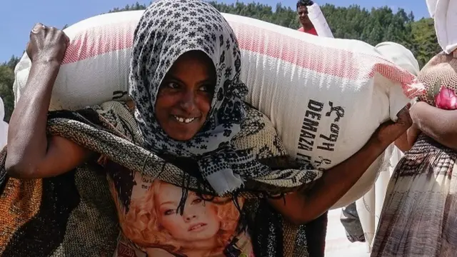 በአማራ ክልል በጭና አካባቢ የምትኖር ሴት ስንዴ ተሸክማ