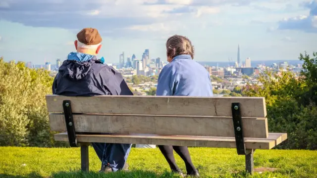 pareja mayor en un parque con vistas a la ciudad