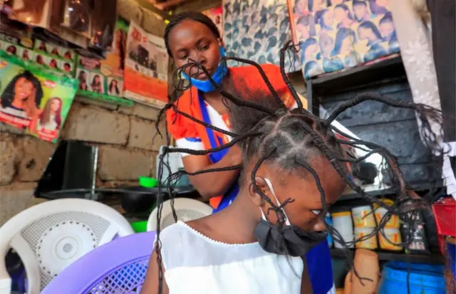 A child has her hair threaded in a salon in Kenya's capital, Nairobi - 29 April 2020