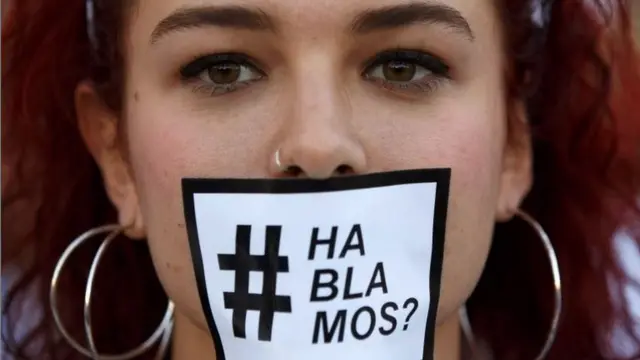 Joven con un papel en la boca que dice Hablamos