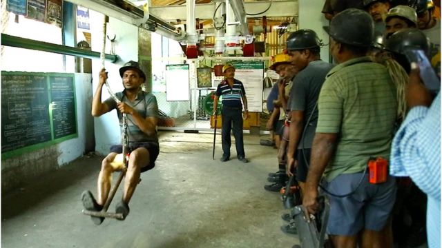 మేన్ రైడింగ్ ద్వారా గనిలోకి వెళ్తున్న కార్మికుడు