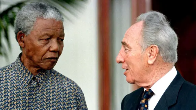 साल 1996 में दक्षिण अफ़्रीका के केपटाउन में राष्ट्रपति नेलशन मंडेला से मिलते शिमोन पेरेज़.