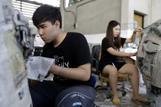 นักศึกษา มธ. ช่วยกันทาสีตกแต่งหุ่นสำหรับนำไปแสดงในขบวนพาเหรดล้อการเมือง ในงานฟุตบอลประเพณีจุฬา-ธรรมศาสตร์ ครั้งที่ 72