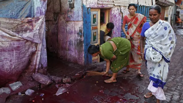 ఇంటి పరిసరాలను శుభ్రం చేస్తున్న మహిళ