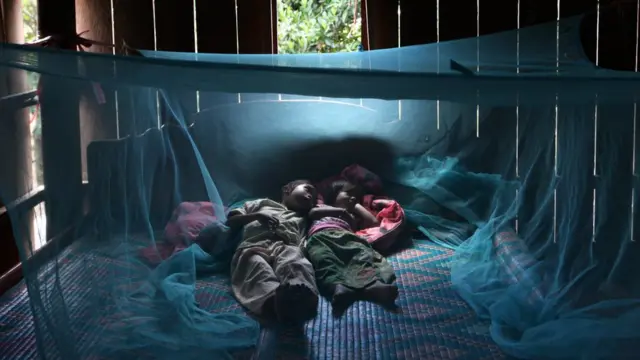 sister Montra,3, and brother Leakhena, 4months under a mosquito bed net