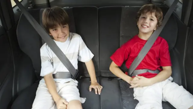 Niños con cinturón de seguridad en el carro