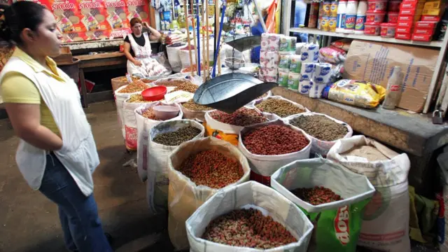 แม่ค้ายืนขายเมล็ดพันธุ์ที่ตลาดสด