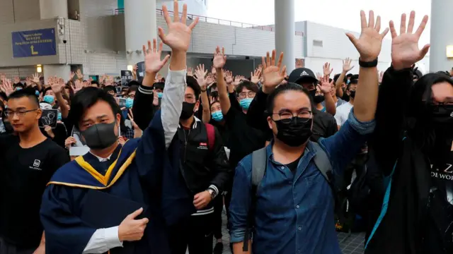University students hold their hands in the air