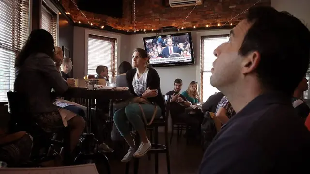 Посетители кафе перед телевизором