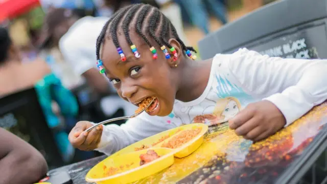Pikin wey dey chop jollof rice.
