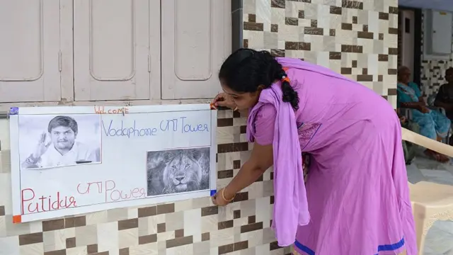 हार्दिक के घर उनके नाम का पोस्टर लगाती उनके परिवार की महिला (फ़ाइल फ़ोटो)