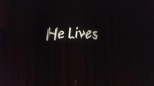 عبارة "يعيش" على ستارة سوداء في نهاية المعرض