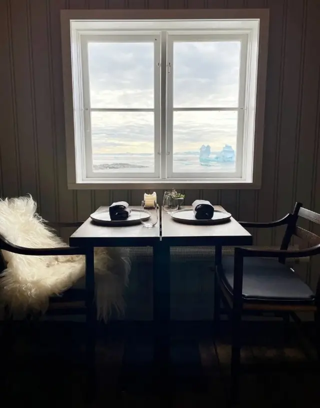 U svećama osvetljenom prostoru restorana Koks, stolice su prekrivene ovčijim krznom