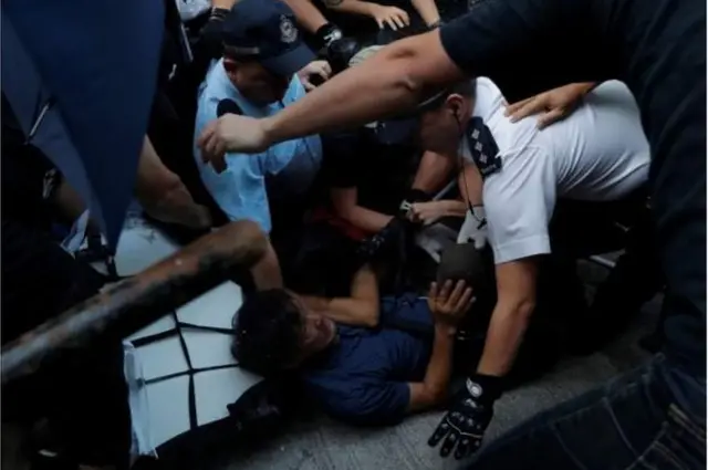 హాంకాంగ్లో నిరసనలో పాల్గొన్నవారిని అరెస్టు చేస్తున్న పోలీసులు