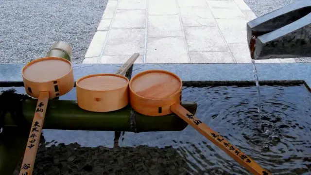 Перед тем, как войти в синтоистский храм, пришедшие помолиться омывают руки и рот водой из каменной чаши у входа