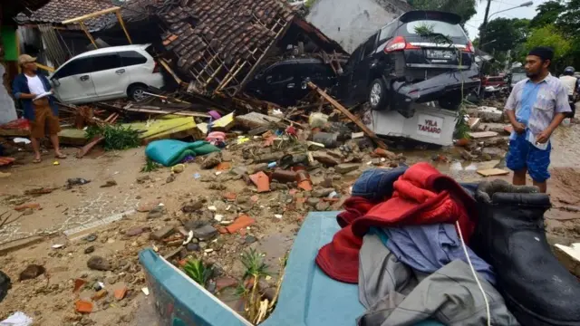 Bangunan rumah dan mobil porak poranda diterjang gelombang tsunami Sabtu (22/12).