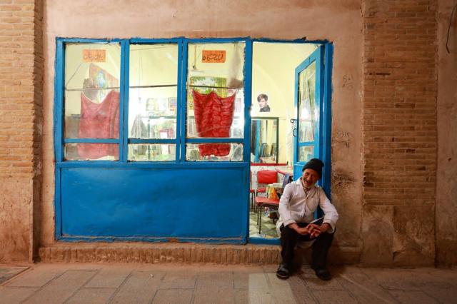 بازار کرمان؛ علی - ۸۰ ساله - علیرغم بیماری پارکیسنون به کار آرایشگری مشغول است