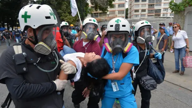 Seorang perempuan diangkut anggota paramedis saat berlangsung unjuk rasa menentang Presiden Maduro di Caracas, Juni 2017