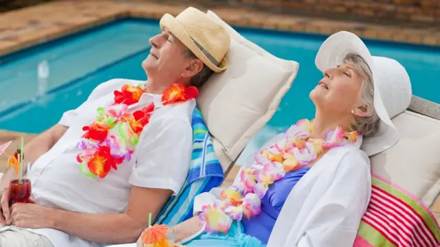 Casal idoso descansa na piscina