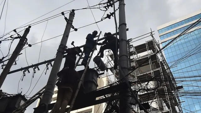 ঢাকা ইলেকট্রিক সাপ্লাই কোম্পানির কর্মীরা বিদ্যুৎ লাইন মেরামত করছেন।