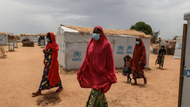 Un groupe de femmes traverse le camp de déplacés de Bogo lors d'une visite sur le terrain de Filippo Grandi, Haut Commissaire des Nations Unies pour les réfugiés (HCR) à Maroua, le 28 avril 2022.