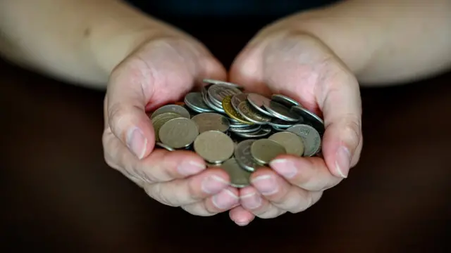 A person holds Korean coins in their hands.