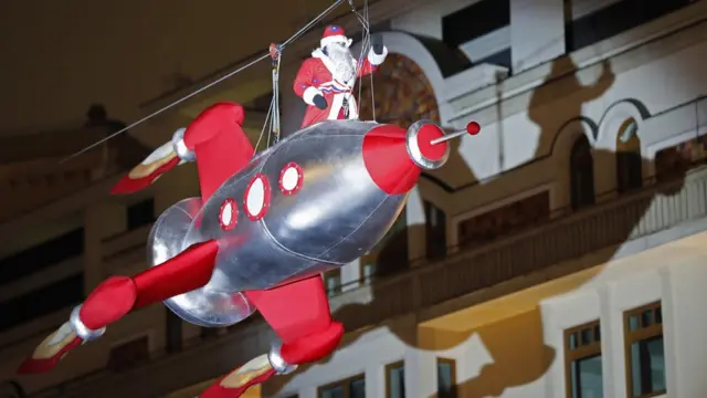 Человек в костюме Деда Мороза на ракете