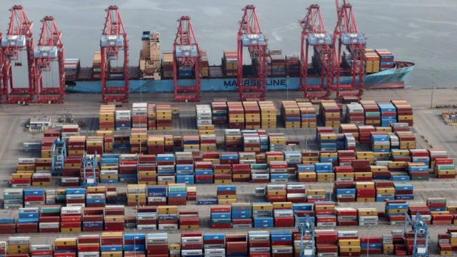 Una vista aérea de contenedores en el muelle junto a un buque.