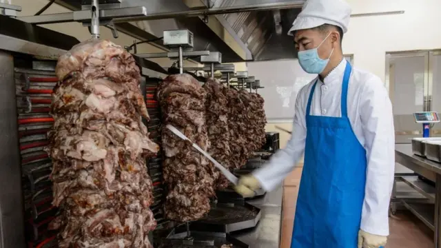 2021년 9월 24일 평양 금송식품공장에서 한 직원이 고기를 썰고 있다.