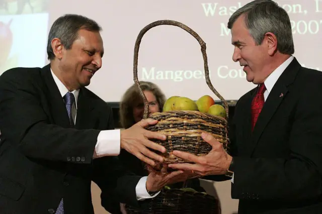 L'ambassadeur indien Ronen Sen (à gauche) remet un panier de mangues indiennes au secrétaire américain à l'Agriculture Mike Johanns lors d'une cérémonie célébrant l'ouverture du commerce de mangues entre les États-Unis et l'Inde au ministère du Commerce à Washington, le 1er mai 2007.