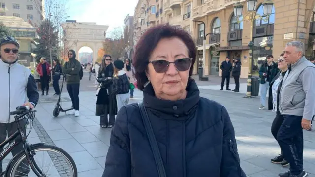 Старија жена са наочарима за сунце и у зимској јакни